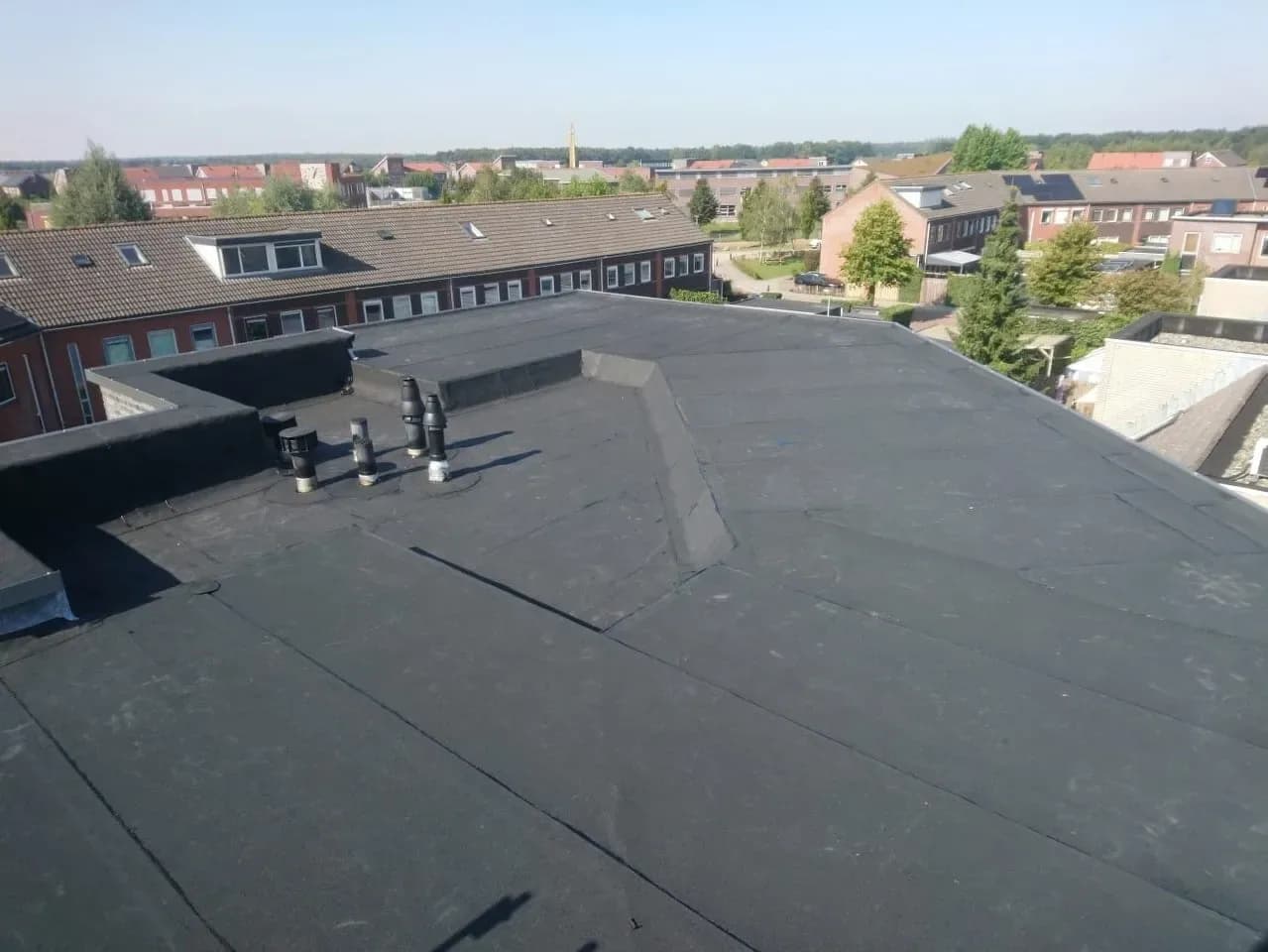 Nieuw bitumendak met strakke afwerking en detailwerk bij opstanden