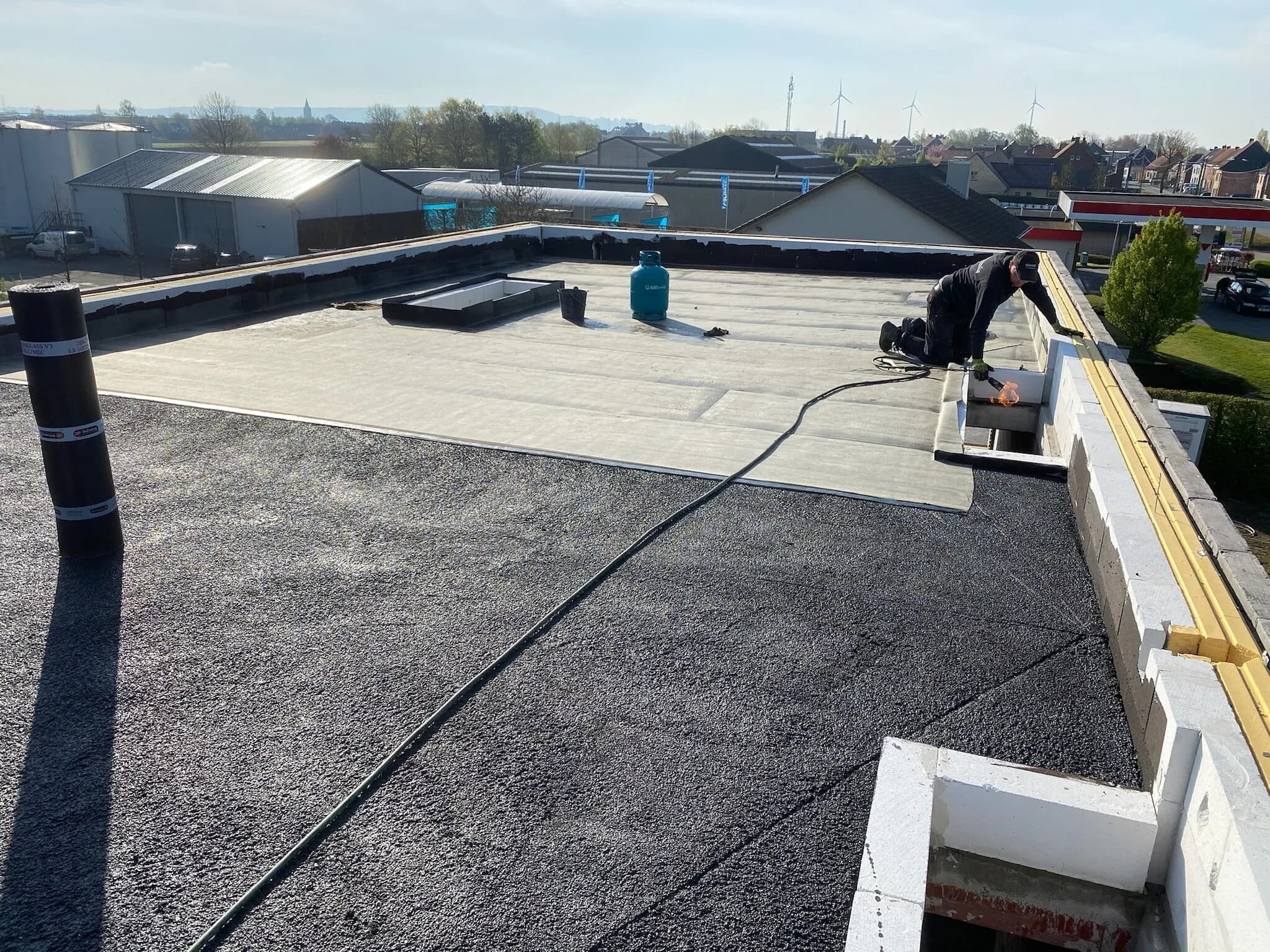 Vakman werkt aan detailwerk en opstanden tijdens plat dak renovatie