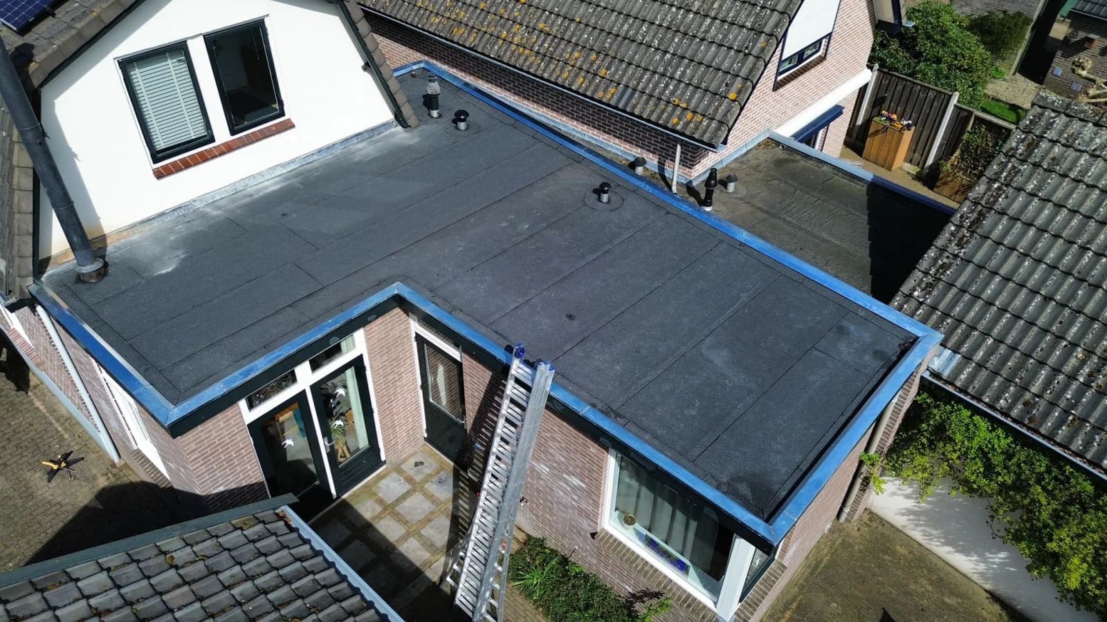 Plat dak vernieuwd met bitumen en zinken deklijsten, beeld 2
